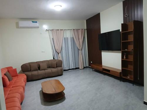 ein Wohnzimmer mit Couch und Flachbildfernseher in der Unterkunft Villa Standing Ngaparou in Ngaparou