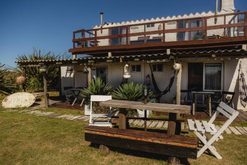 a house with a bench in front of it at Carmela Suites Cabo Polonio in Cabo Polonio
