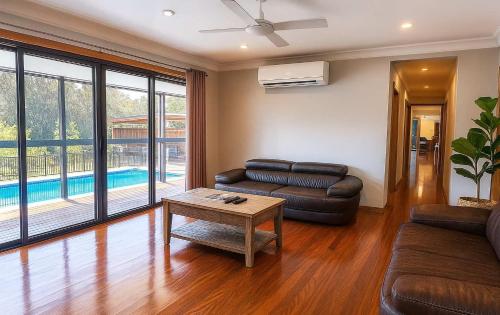 a living room with a couch and a table at Chardonnay Escape in Pokolbin