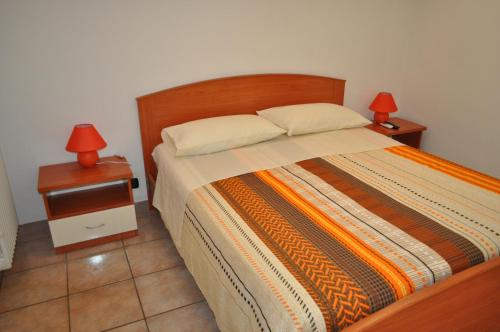 マテーラにあるLa Specchiaのベッドルーム1室(ベッド1台、ナイトスタンド2台、ランプ2つ付)