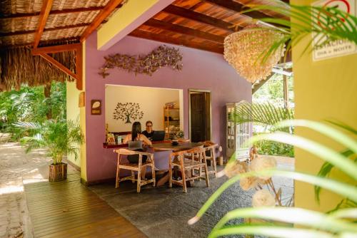 two people sitting at a table in a house at Recanto da Mata Pipa in Pipa