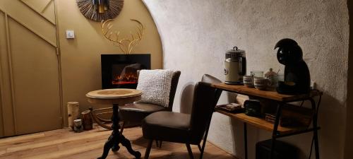a room with a table and a chair and a table and a stove at Charmante suite indépendante avec cave à vin in Cournonsec
