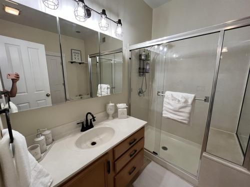 ein Badezimmer mit Waschbecken und Glasdusche in der Unterkunft Cozy home in Soulard in Saint Louis