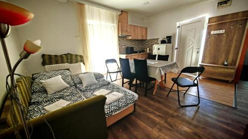 a living room with a couch and a table with chairs at Ezee Rider Apartmanok in Sárvár
