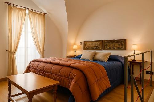 a bedroom with a bed and a table and a window at Damiani Appartamenti nel Centro Storico di Palermo in Palermo