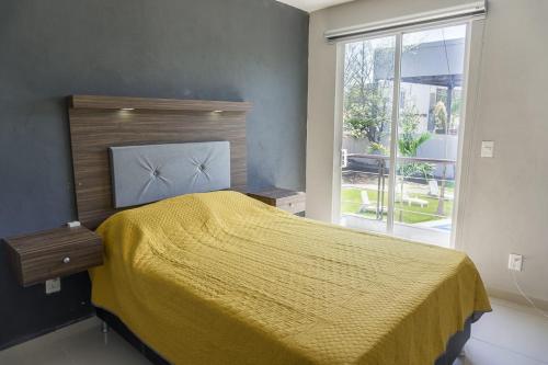 a bedroom with a yellow bed and a window at Casas Diamante in Xochitepec