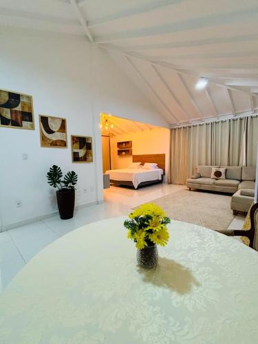 a living room with a bed and a table with yellow flowers at Ceta Ecotel in Macapá