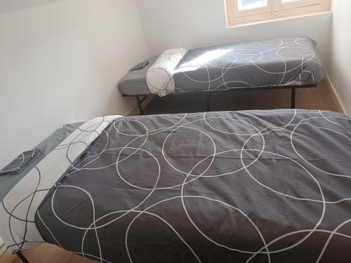 two beds sitting in a room with at La fin de journée-T3-Wifi-parking in Saint-Yrieix-sur-Charente