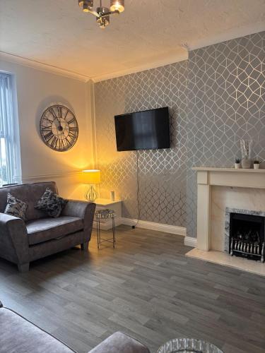 a living room with a couch and a fireplace at Chestnut Lodge - a woodland escape near the city! in Bradford
