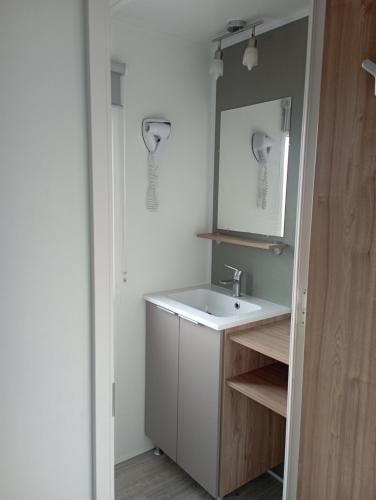 a bathroom with a white sink and a mirror at Val'B ocean-bord de plage in Sarzeau