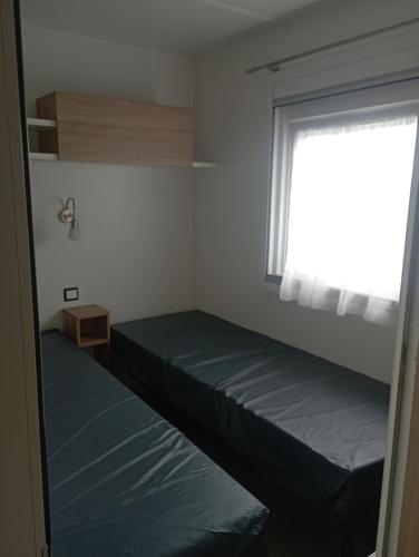 a small bedroom with two beds and a window at Val'B ocean-bord de plage in Sarzeau