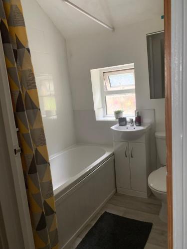 a bathroom with a tub and a toilet and a sink at Chestnut Lodge - a woodland escape near the city! in Bradford