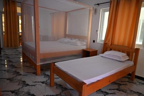 Firas Village في واتامو: سريرين في غرفة مع سريرين sidx sidx