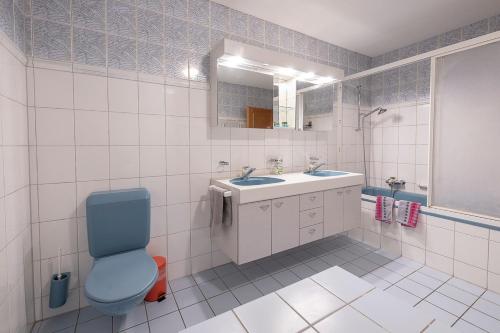 a bathroom with a blue toilet and a sink at Gasthof zur alten Post in Büren an der Aare