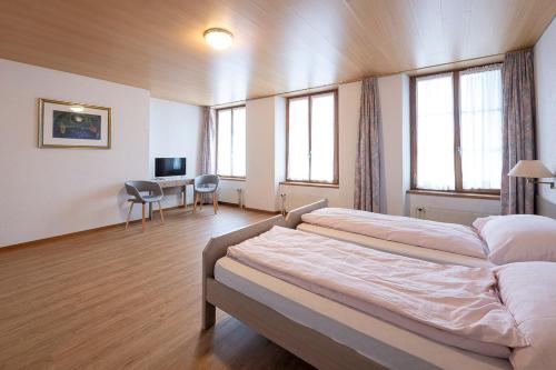 a bedroom with two beds and a table and chairs at Gasthof zur alten Post in Büren an der Aare