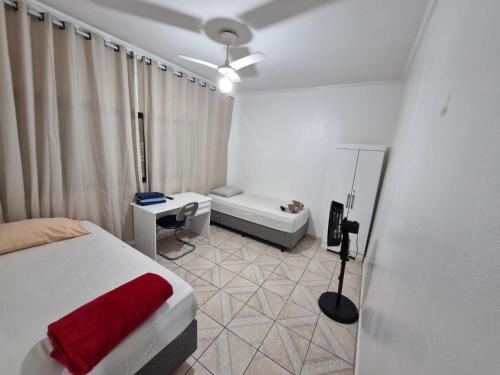 een slaapkamer met een bed, een tafel en een bank bij Hotel Pousada Liberdade in Pindamonhangaba