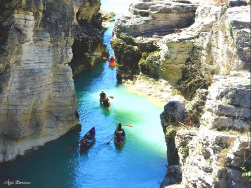 three people in canoes in a river between cliffs at Villa Rosa in Acqualagna