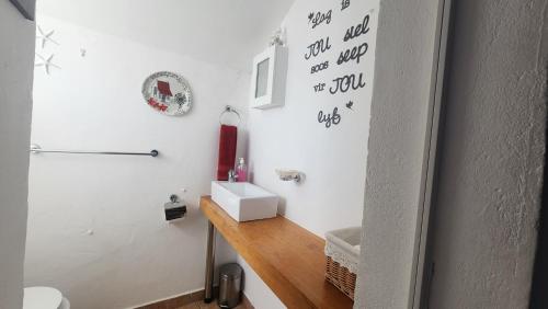 un baño con lavabo e inodoro en Pamperlang, en Dwarskersbos