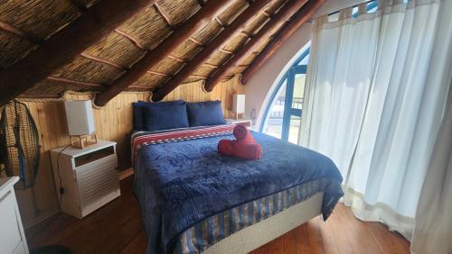Un dormitorio con una cama con un juguete rojo. en Pamperlang, en Dwarskersbos