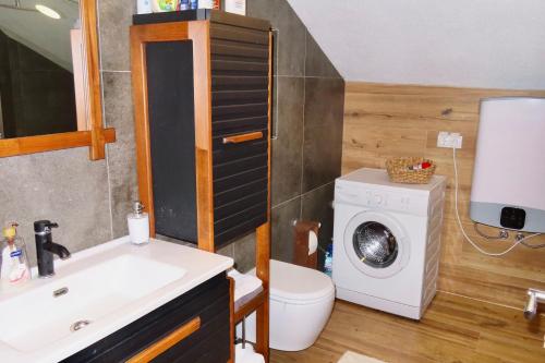a bathroom with a sink and a washing machine at Chez Vila in Prizren