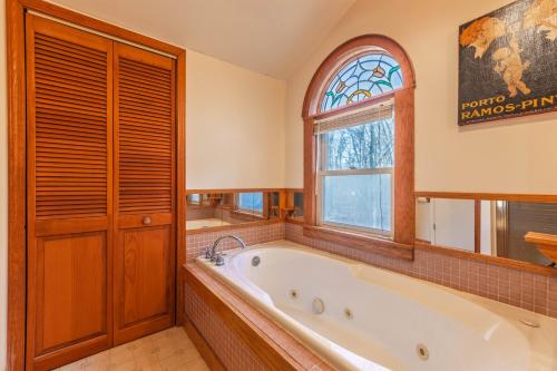 a bathroom with a tub and a window at Charming 3 bed 2 bath home near dunes, beach and trails in South Haven