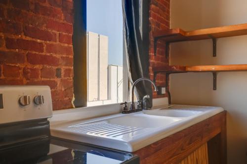 a kitchen with a sink and a brick wall at Convenient Couples Retreat in Dtwn Marshall! in Marshall