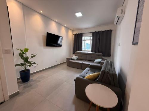 a living room with a couch and a table at Apê pé na areia in Santos