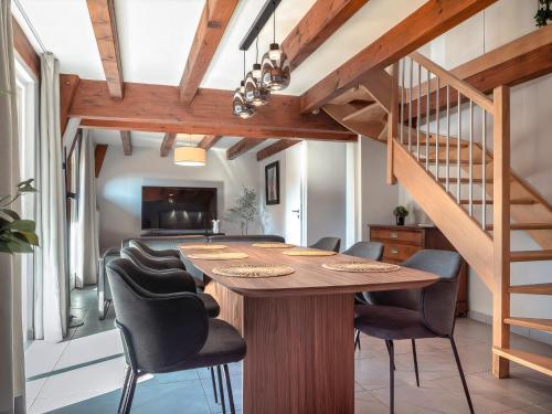 a dining room with a wooden table and chairs at Résidence 90 m2 lumineuse - cour intérieure alsacienne, balcon & parking in Marlenheim