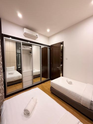a bedroom with two beds and a large mirror at Dorsett Residences Executive KL in Kuala Lumpur