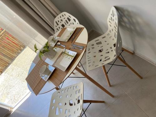 une table et des chaises dans une pièce avec une fenêtre dans l'établissement AnaManô Flat térreo, à São Miguel dos Milagres