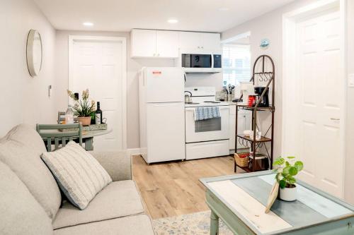 ein Wohnzimmer mit Couch und Küche in der Unterkunft Cozy Coastal Cottages of Dunedin 3 in Dunedin