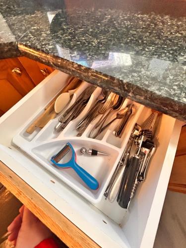 uma pia em uma gaveta sob a bancada com utensílios em Entire floor in a Spacious bungalow ensuite close to beach and train em Pincourt