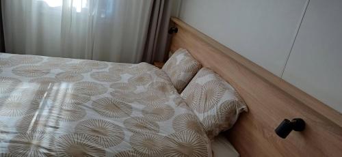 1 cama con cabecero de madera y almohadas en Le panoramique, en Saillagouse