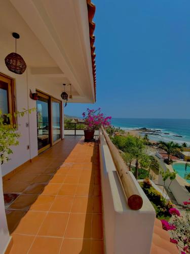 a balcony of a house with a view of the ocean at Hotel Boutique casa la Malagueña in San Agustinillo