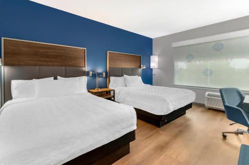a hotel room with two beds and a blue wall at Tru By Hilton Goodlettsville Nashville in Goodlettsville