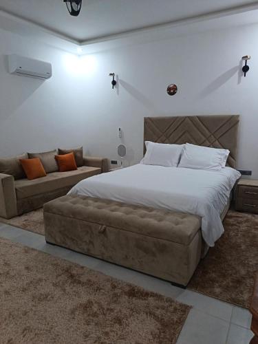 a bedroom with a large bed and a couch at Dar naima in Al Ghar