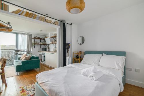 une chambre avec un lit blanc et une chaise verte dans l'établissement Charming Central Studio with Balcony in Birmingham, à Birmingham