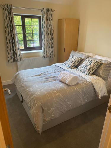 a large bed in a bedroom with a window at Chimney View Annexe in Wootton