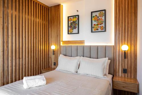 a bedroom with a bed with two lamps on the wall at Cozy apartment with fantastic gym and pool in Asuncion