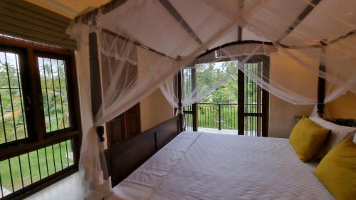 a bedroom with a canopy bed with windows at Welpalla Signature 