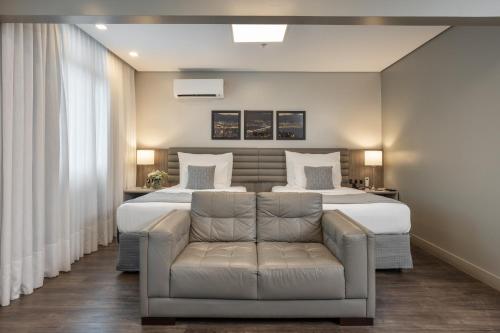 a bedroom with two beds and a couch at Blue Tree Premium Florianópolis in Florianópolis
