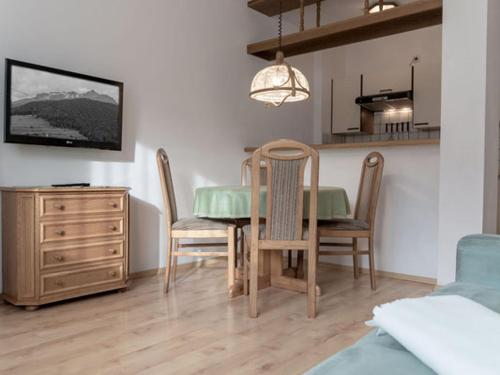 een eetkamer met een tafel en stoelen en een keuken bij das Alpenblick & Outdoor Lodge Nauders in Nauders