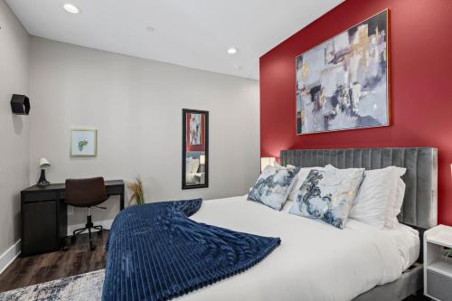 a bedroom with a large bed with a red wall at JoyFull 2BD In the Heart of Magnolia in Fort Worth
