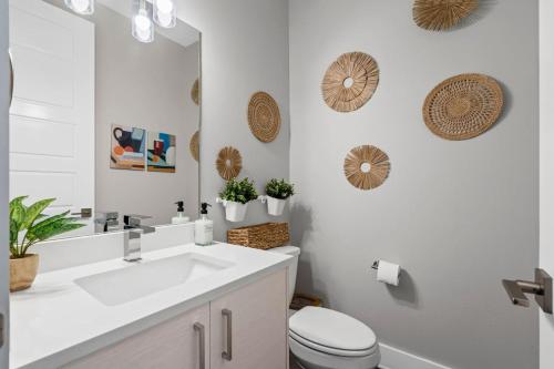 a bathroom with a sink and a toilet and a mirror at JoyFull 2BD In the Heart of Magnolia in Fort Worth