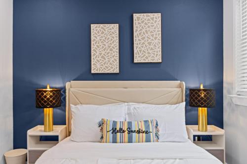 a bedroom with blue walls and a bed with two lamps at The Quartz 2BD Townhouse in the heart of FW in Fort Worth