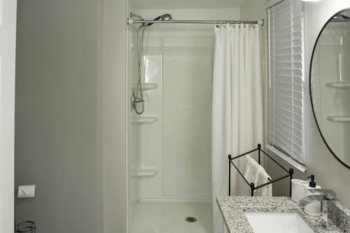 een witte badkamer met douche en wastafel bij Lake Daze Landing in Greer