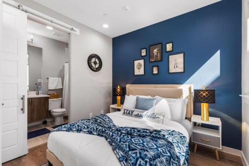 a bedroom with a blue accent wall and a bed at The Coral 2BD TownHouse 7ST Walkable in Fort Worth