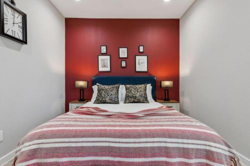 a bedroom with a bed with a red wall at The Euclase 2BD TownHouse in the heart of FortWorth in Fort Worth