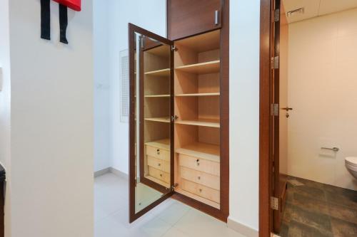 MushayribにあるBright 1-Bedroom in Gate Towers Reem Islandの鏡と洗面台のある更衣室