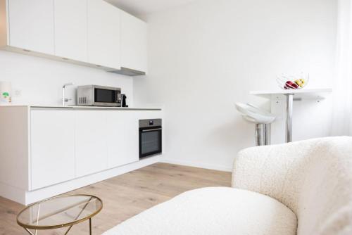 The Mini Minimalist Free Parking في Pully: مطبخ أبيض مع أريكة وميكروويف
